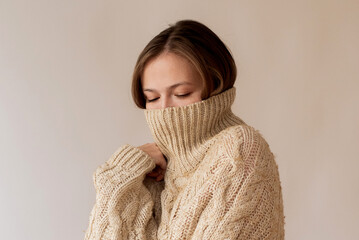 Woman hides her face in a turtleneck 