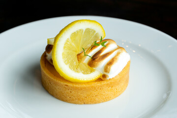 Closeup of a homemade lemon tart decorated and lime slices
