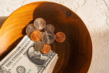 Dollar bill and change in bowl