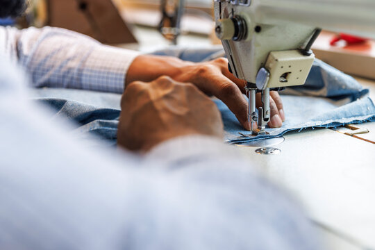 Cropped image of tailor using sewing machine at workshop