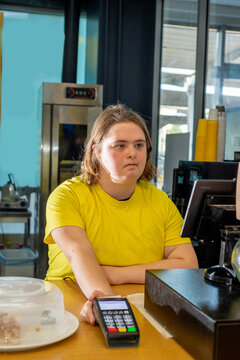 Young woman with Down syndrome works at the cash register