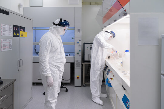Two Scientists Working At Clean Room 