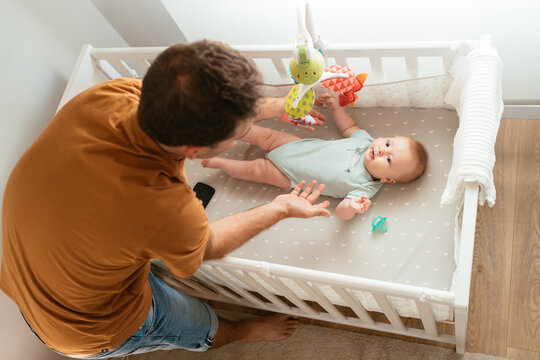 Father taking baby from crib after sleep