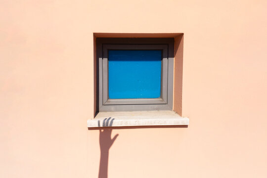 Shadow hand reaches toward the blue window / shadow play