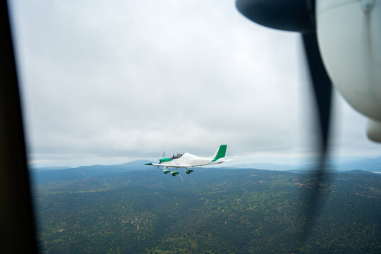 View From An Airplane Window Of Another Plane Flying Nearby.
