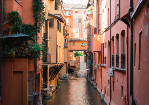 Iconic canal street in Bologna with colorful orange and yellow houses