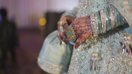 Hand of bride with wedding ring and bangles