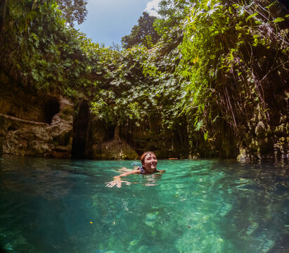 Woman Swimming In A Cenote Lagoon In Mexico. 