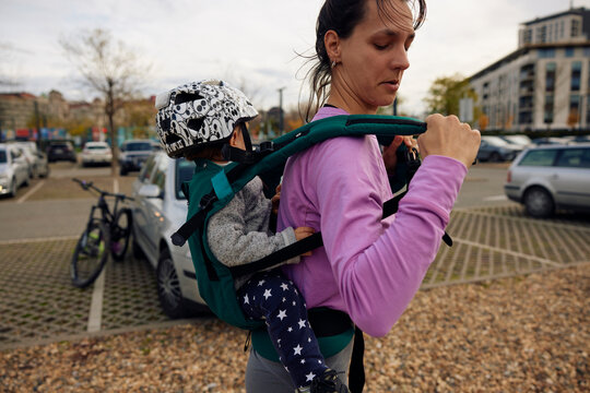 Athlete woman adjusts straps of a baby carrier