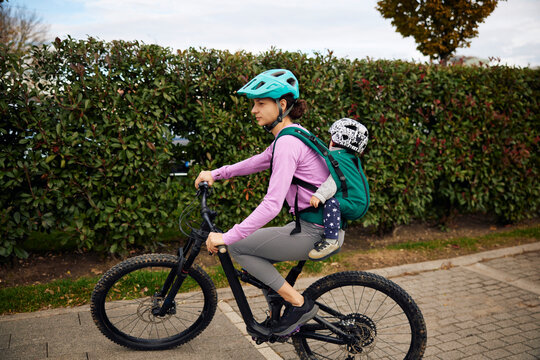 Active woman goes cycling with her kid