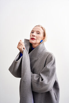 Fashionable portrait of an older model in a gray oversized coat
