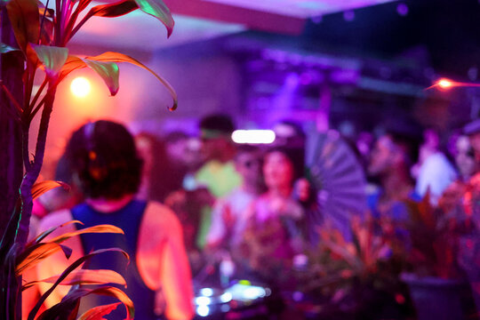 Neon color anonymous people enjoying tropical electronic party vibe