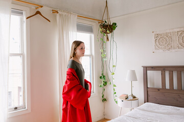 High school senior on red gown at home