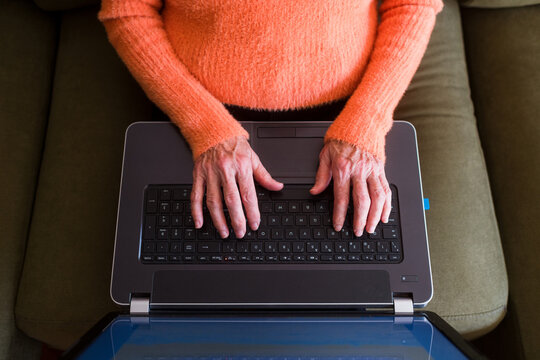 Senior woman hands typing on laptop keyboard