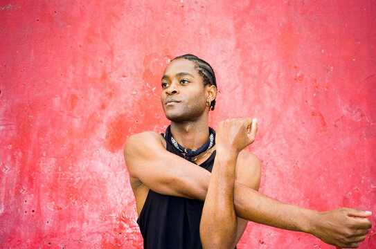 Young black athlete exercises to improve his flexibility in a park