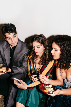 Concerned friends looking at phone at a party