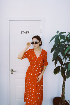 A young woman posing and pulling down her sunglasses