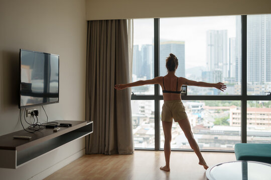Young Woman Doing Fitness Workout At Home With CIty View