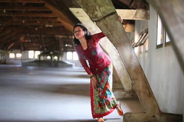 Javanese woman in her traditional dress, posing in the attic of an old colonial building