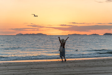View of a female tourist on the beach against the sunset
