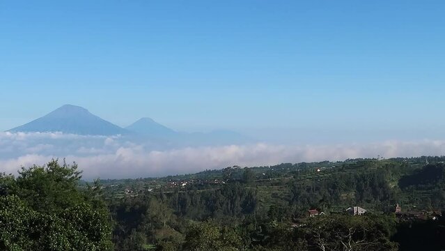 View of majestic volcano mount Merapi and mount Merbabu over tropical landscape in central java Indonesia