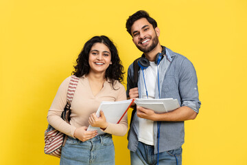 Students With Books And Backpack Standing Against Yellow Background
