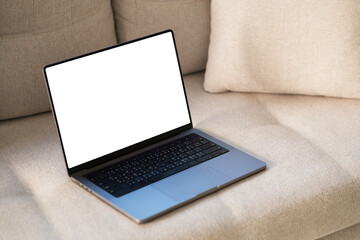 Laptop computer with blank screen on couch sofa with pillows. Aesthetic elegant styled home living...