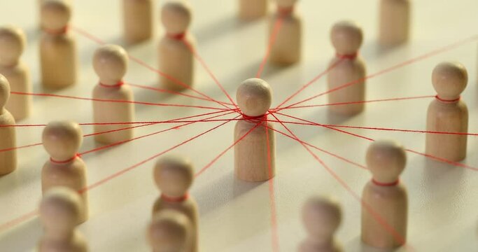 Wooden figures of men connected by red threads, symbolizing a social network