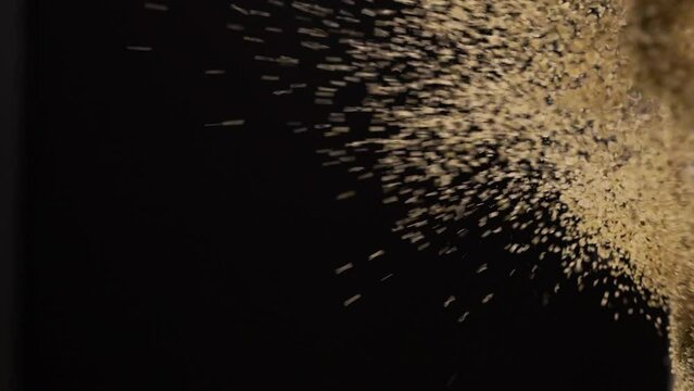 Small grains floating in the air against black background