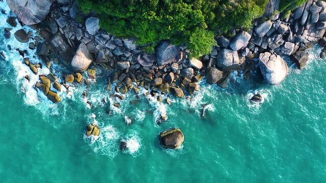 Drone video backdrop of sea wave in bird eye waves. Waves crushing on rocks on the beach. 