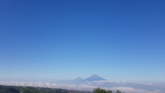View of majestic volcano mount Merapi and mount Merbabu over tropical landscape in central java Indonesia