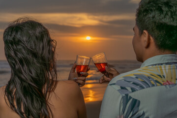 Couple in love toasting looking at the sea at sunset