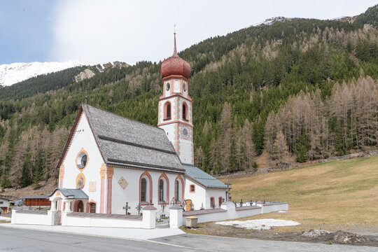 Beautiful small church in Gries im Sellrain, Längenfeld during early spring time. Austrian mountains in the background. Typical architectural style from Tyrol, Austria with onion dome.