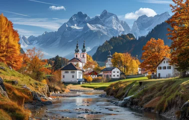 Schilderijen op glas A picturesque autumn scene of the idyllic village in Tirol, with its white houses and colorful trees, set against rolling green hills and surrounded by majestic mountains under clear blue skies © Kien
