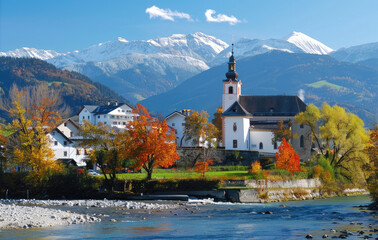 A picturesque autumn scene of the idyllic village in Tirol, with its white houses and colorful trees, set against rolling green hills and surrounded by majestic mountains under clear blue skies