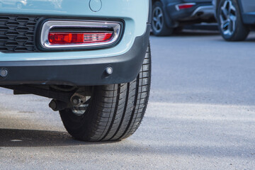 Close-up of car tires and wheel parked on asphalt roads.