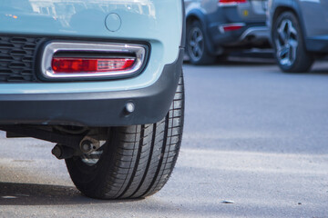 Close-up of car tires and wheel parked on asphalt roads. - 777989423