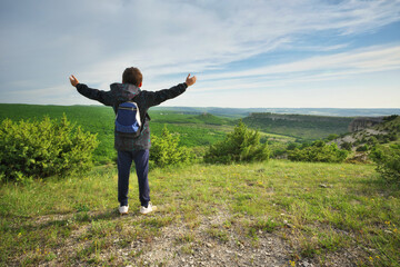 Boy standing and looking at mountainous landscape. - 777989467