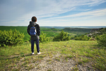Naklejka na ściany i meble Boy standing and looking at mountainous landscape.
