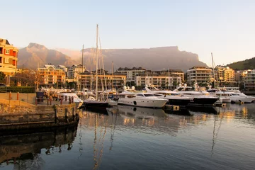 Tableaux sur verre Montagne de la Table Expensive luxury boats in the marina at the V&A Waterfront, with Table Mountain in the Background, in the late afternoon, Cape Town, South Africa