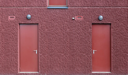Two closed steel doors in a red wall