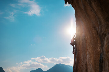 Rock climber on the background of high mountains and blue sky