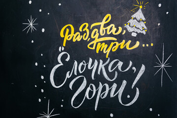 Fototapeta na wymiar Festive Chalkboard Greeting in Russian. A black chalkboard with a festive greeting written in Russian script, featuring white snowflakes and a yellow and white Christmas tree, evoking a cheerful holid