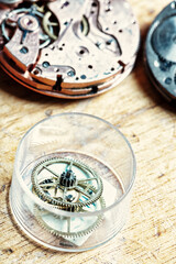 Disassembled watch amid tools on craftsman's bench