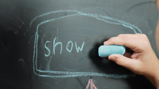 Closeup of smart student or boy hand writing prompt on blackboard. Child planing project and setting engineering system and brainstorm creative idea wrote on blackboard. Focus on hand. Erudition.