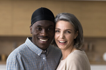 Close up cheerful interracial spouses looking at camera, pose for photo, celebrate wedding anniversary, showing love and care, feel happy, loving couple enjoy strong marriage, harmonic relationships