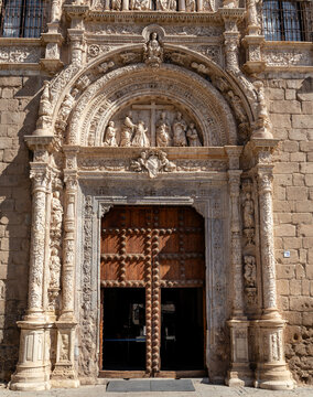 The front of a building with a large archway and a cross on it