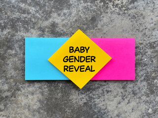 Motivational and inspirational wording. BABY GENDER REVEAL written on adhesive paper. Blurred styled background.