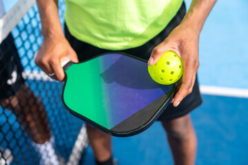 Top view close-up of man holding racket and pickleball ball