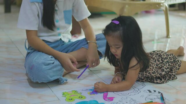 Adorable little asian boy and girl drawing color on paper in cozy house kindergarten child learnning activity